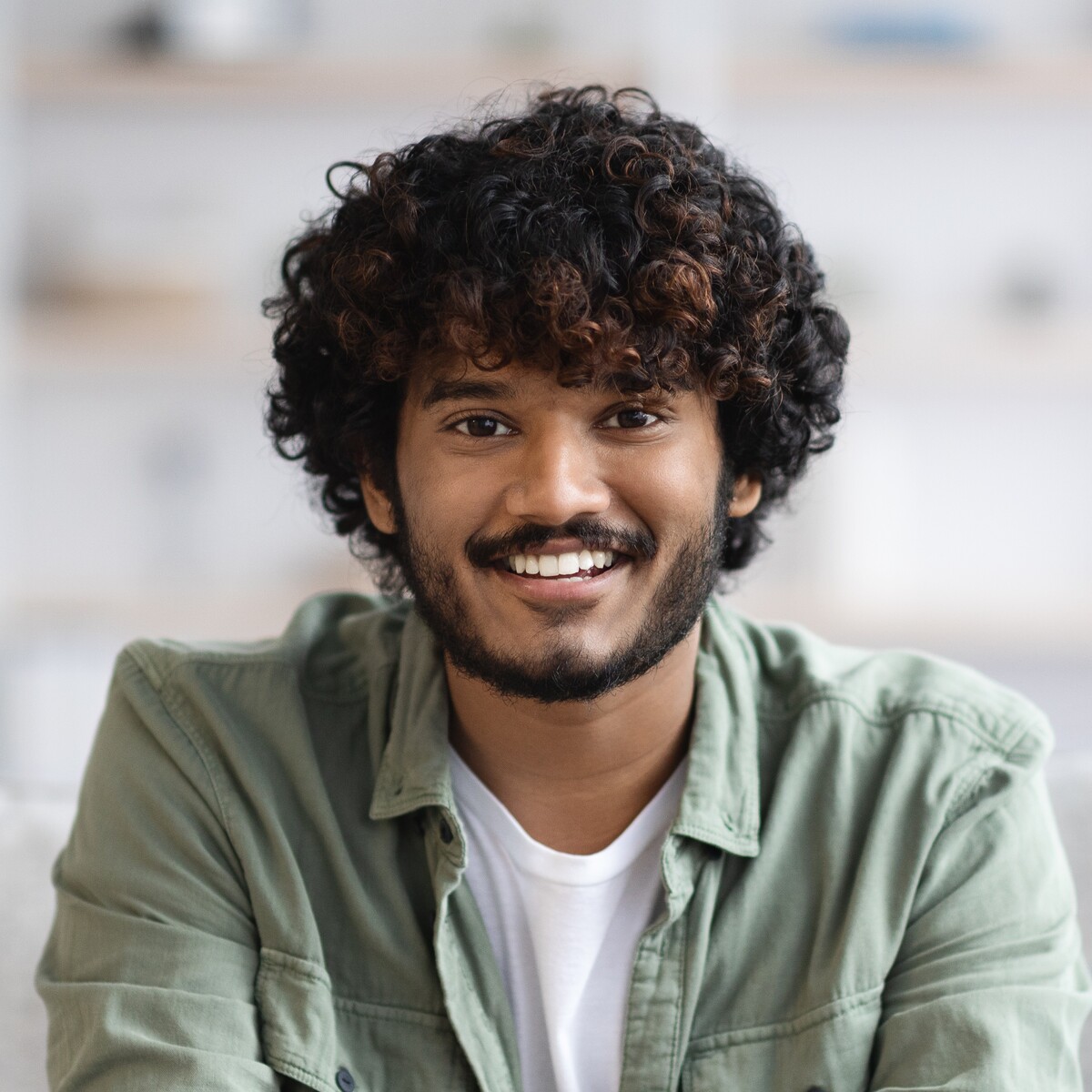 cheerful indian guy posing on couch at home 2025 03 31 11 30 42 utc