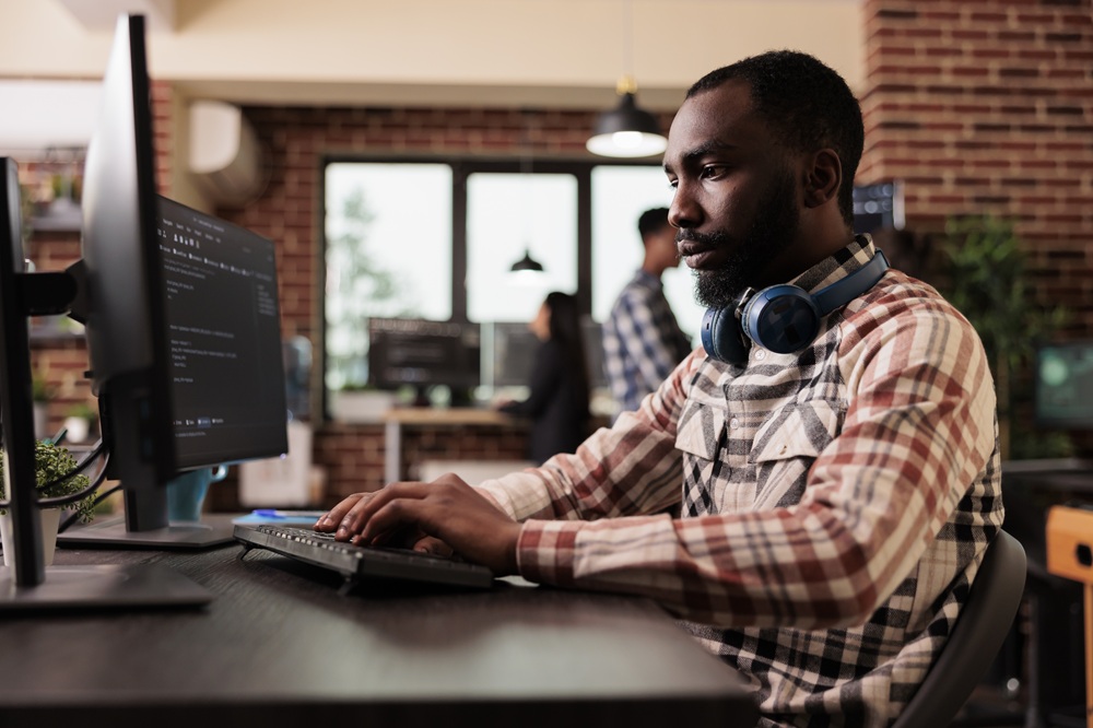freelance coder typing javascript code on computer YPL94X2